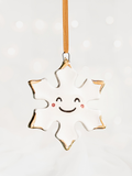 White Snowflake Ceramic Christmas Ornament with a smiley face and Gold Tips