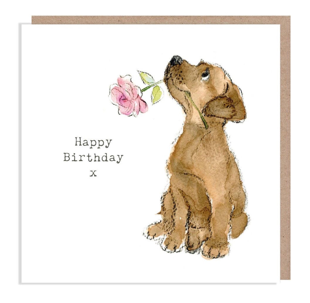 Blank inside Happy Birthday x puppy birthday card with watercolour dog holding a pink flower, includes kraft envelope
