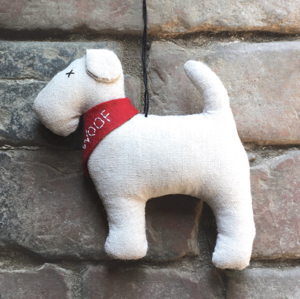 Hanging dog decoration with red scarf with the words woof on from east of India range 